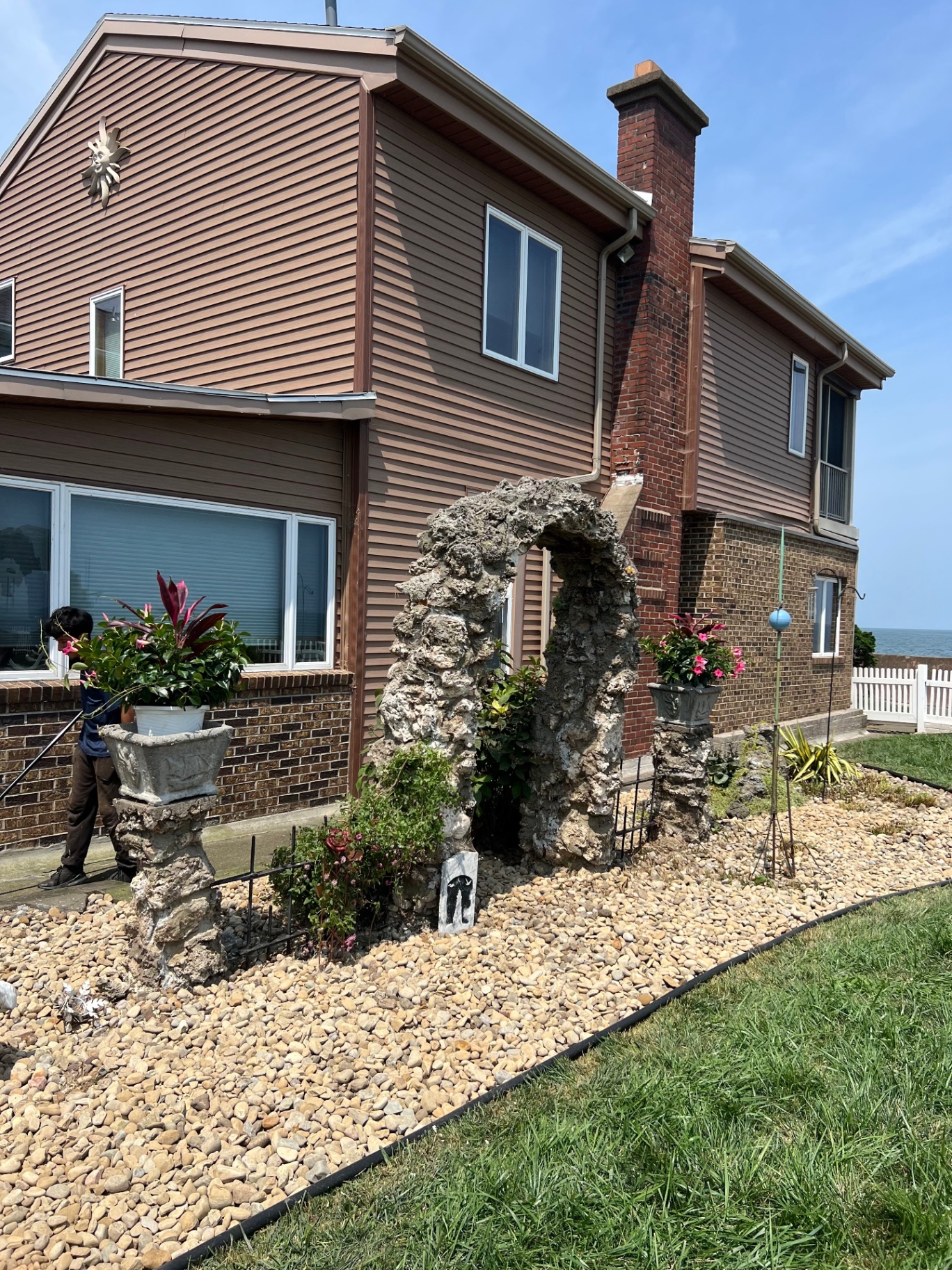 Lakefront rock garden with a stone arch and pea gravel bed